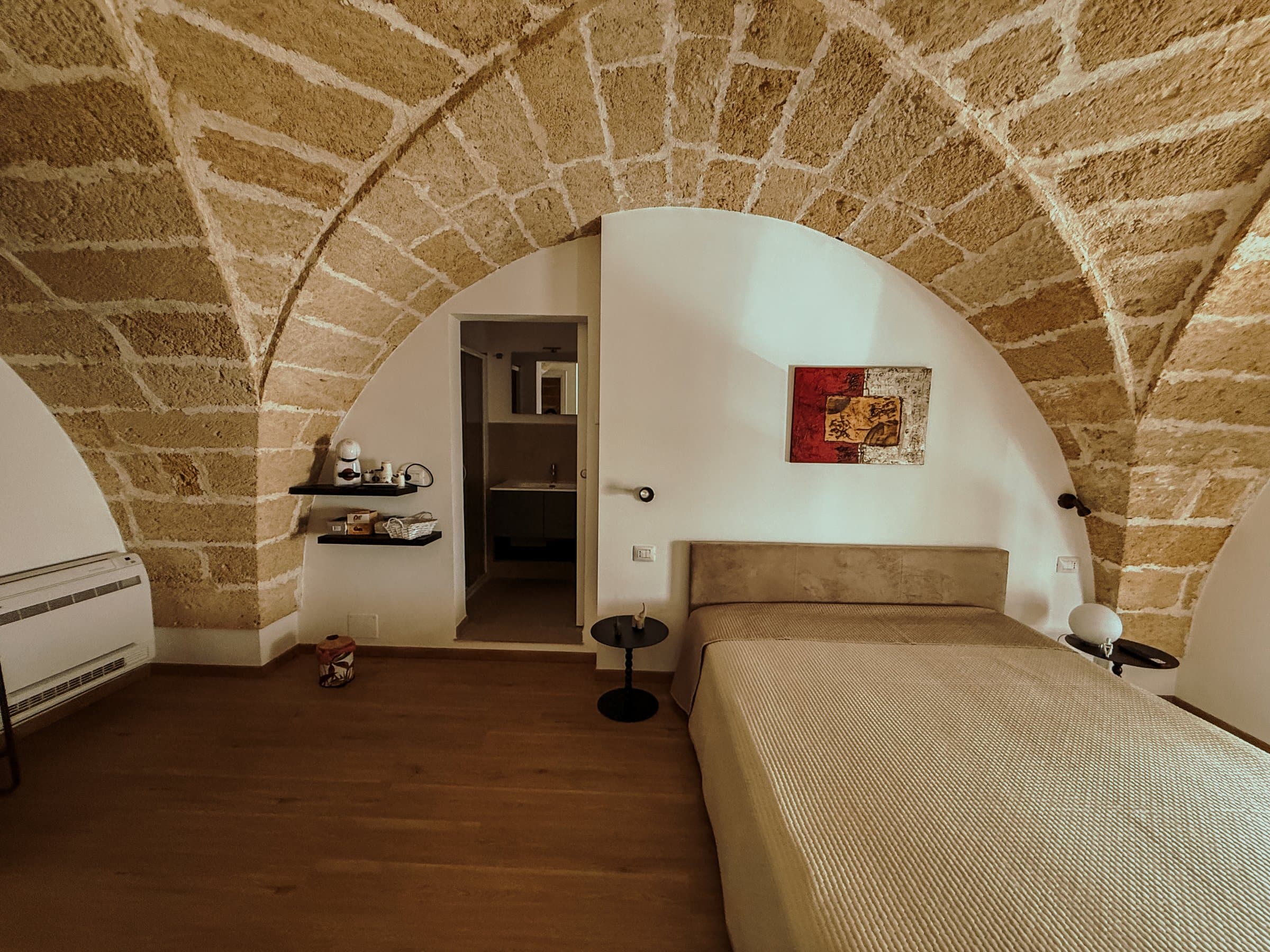 Camera con soffitto a volta e vista sull'ingresso del bagno