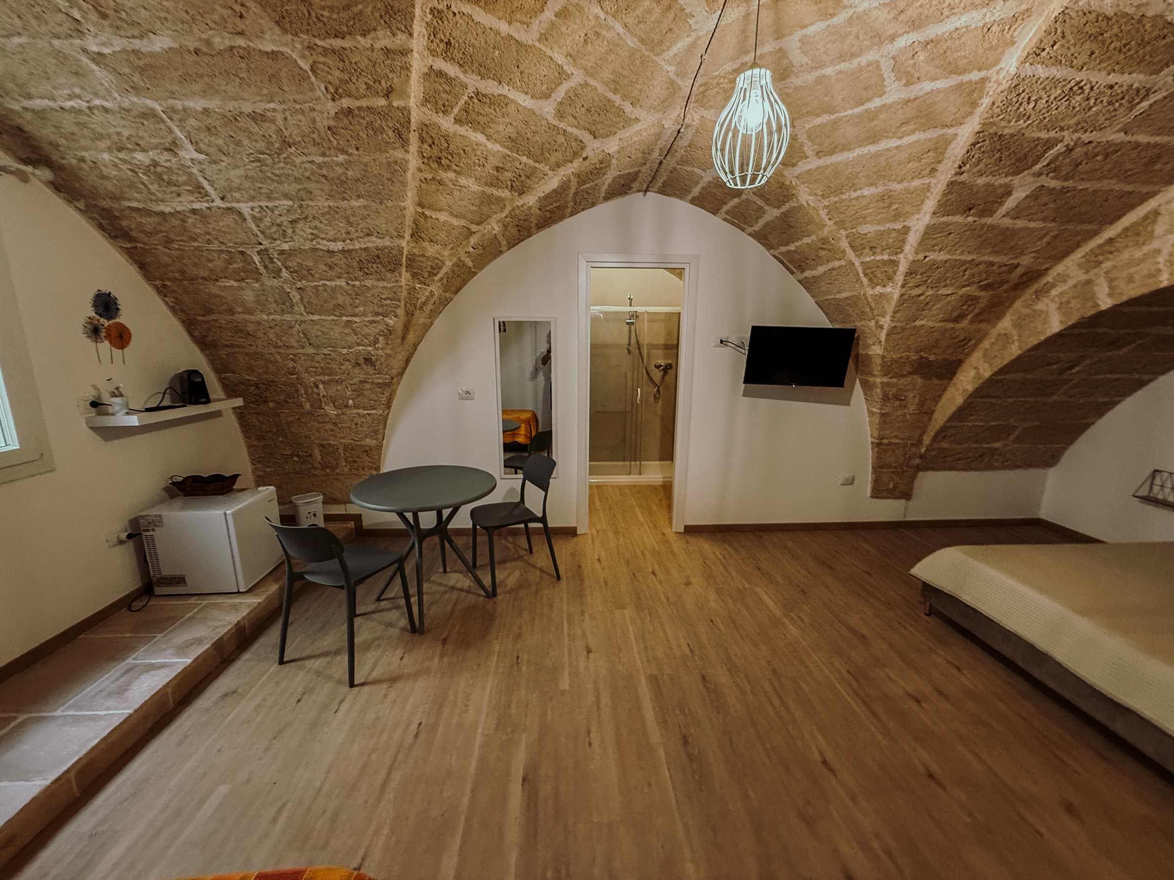 Angolo salottino con tavolino, specchio e vista sul bagno